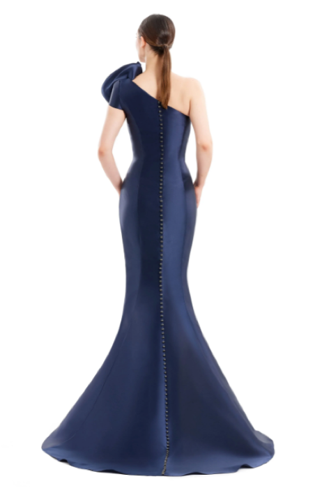 Alexander by Daymor 1673 one-shoulder gown with asymmetric design, pleating, and rosette detail, perfect for formal evening events and mother of the bride or groom. Model is wearing the color navy back view.