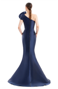 Alexander by Daymor 1673 one-shoulder gown with asymmetric design, pleating, and rosette detail, perfect for formal evening events and mother of the bride or groom. Model is wearing the color navy back view.